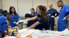 Medical trainees receive instruction by using a medical mannequin.