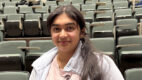 A high school student stands in an auditorium