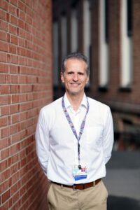 Dr. Michael Rosenblum standing near a brick wall