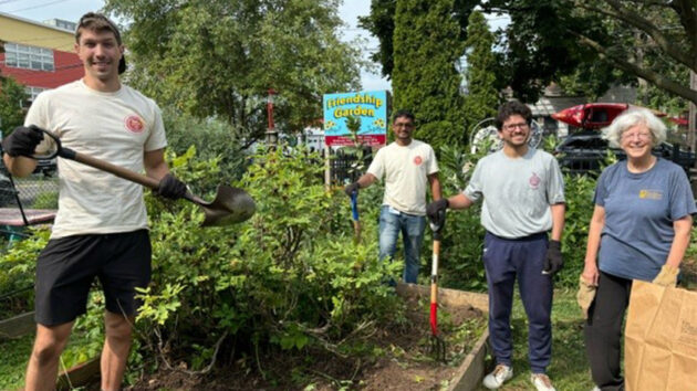 Group of Albany Medical College students with gardening tools, during their Day of Service at the Delaware Community Friendship Garden