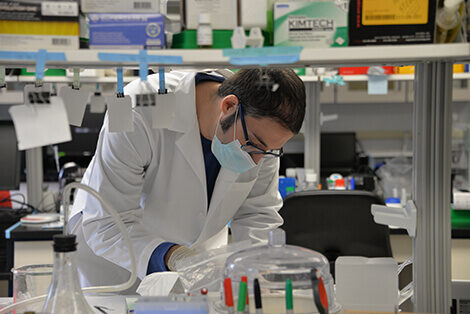 Scientist in a white coat working in a lab